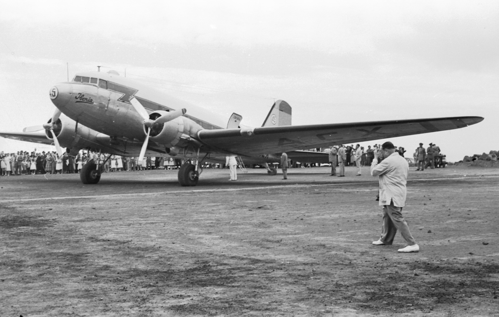 DC-3 visto de lado con un joven descansando en primer plano