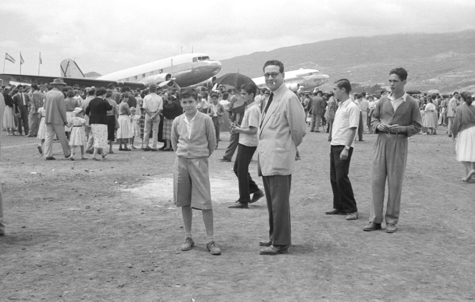 Joven con guayabera y dos hombres posando en la pista