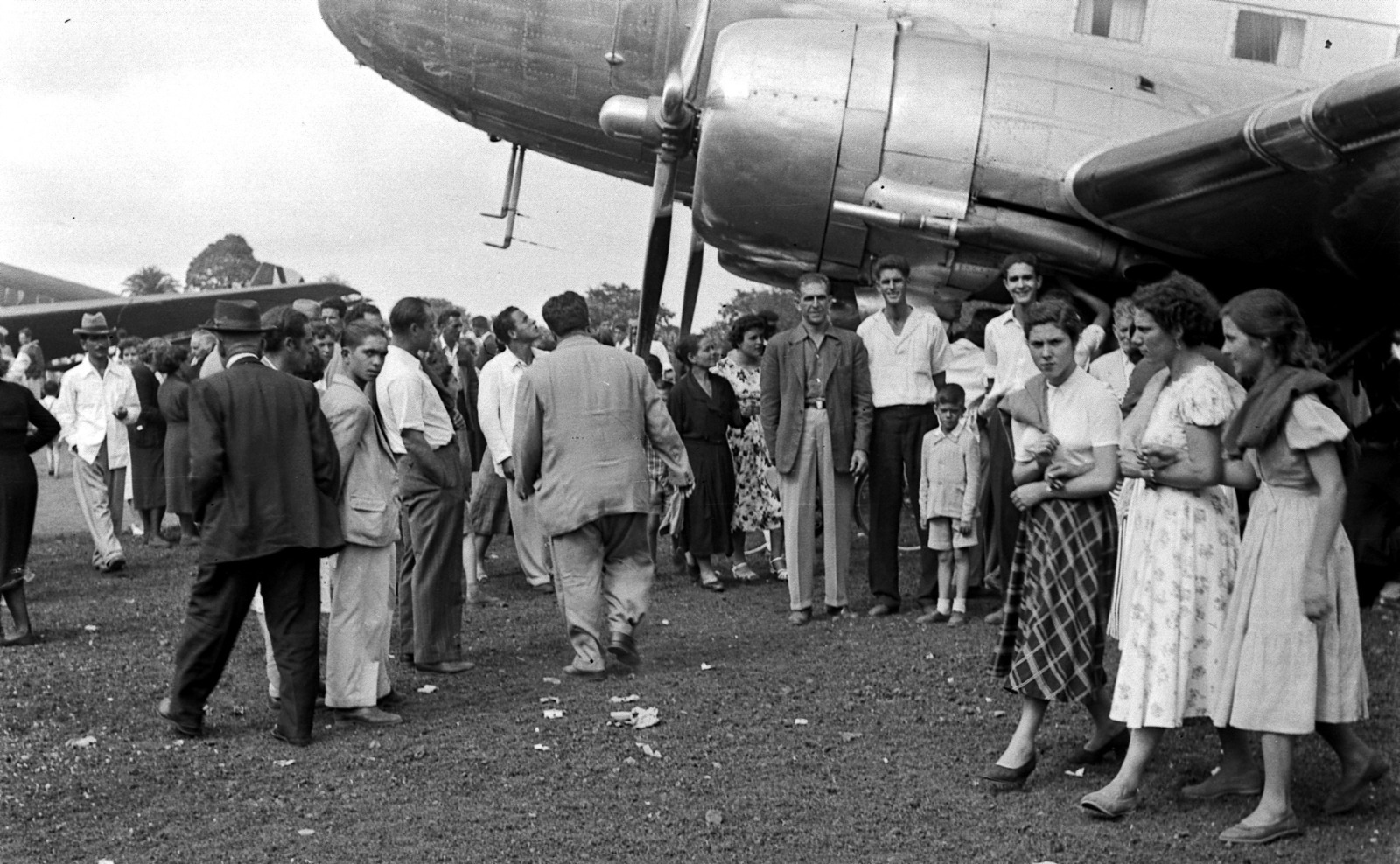 Mujeres y niños bajo el ala del avión