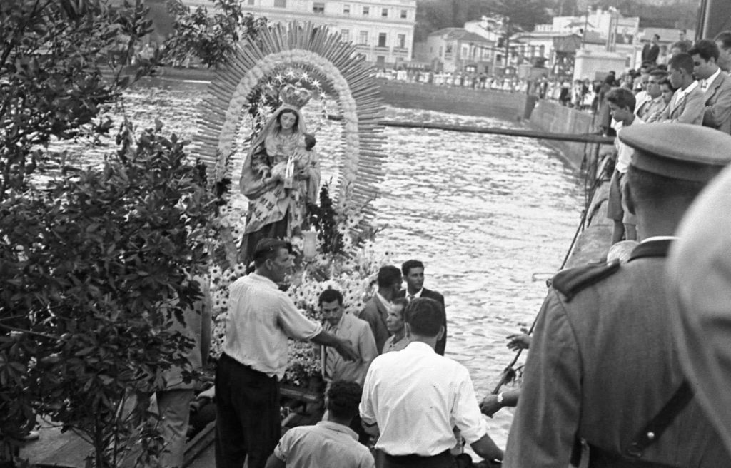 La Virgen del Carmen sobre sus andas durante la procesión, con un guardia civil en primer término