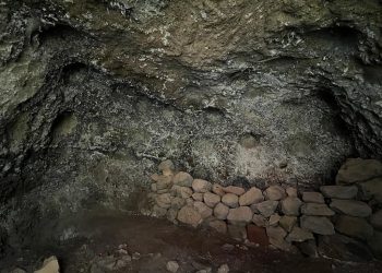 Interior de la cueva artificial con camastro de piedras y cúpulas en Tijarafe