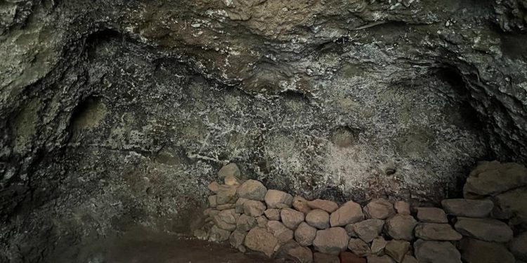 Interior de la cueva artificial con camastro de piedras y cúpulas en Tijarafe
